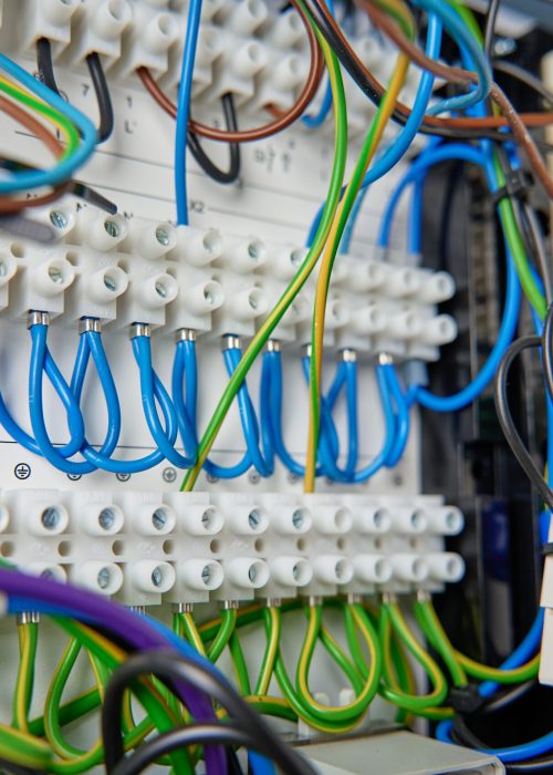 Colorful wires and components connected to terminal block in distribution box. Electrical circuit board with wiring and connections