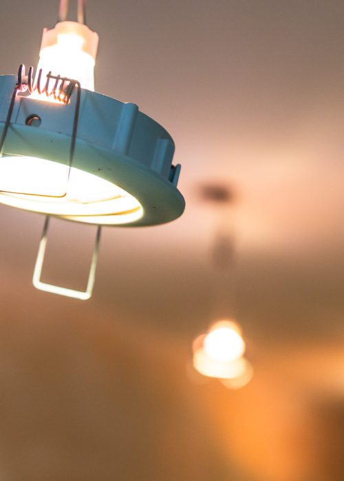 glowing ceiling lamp hangs in plasterboard ceiling during renovation of city apartment